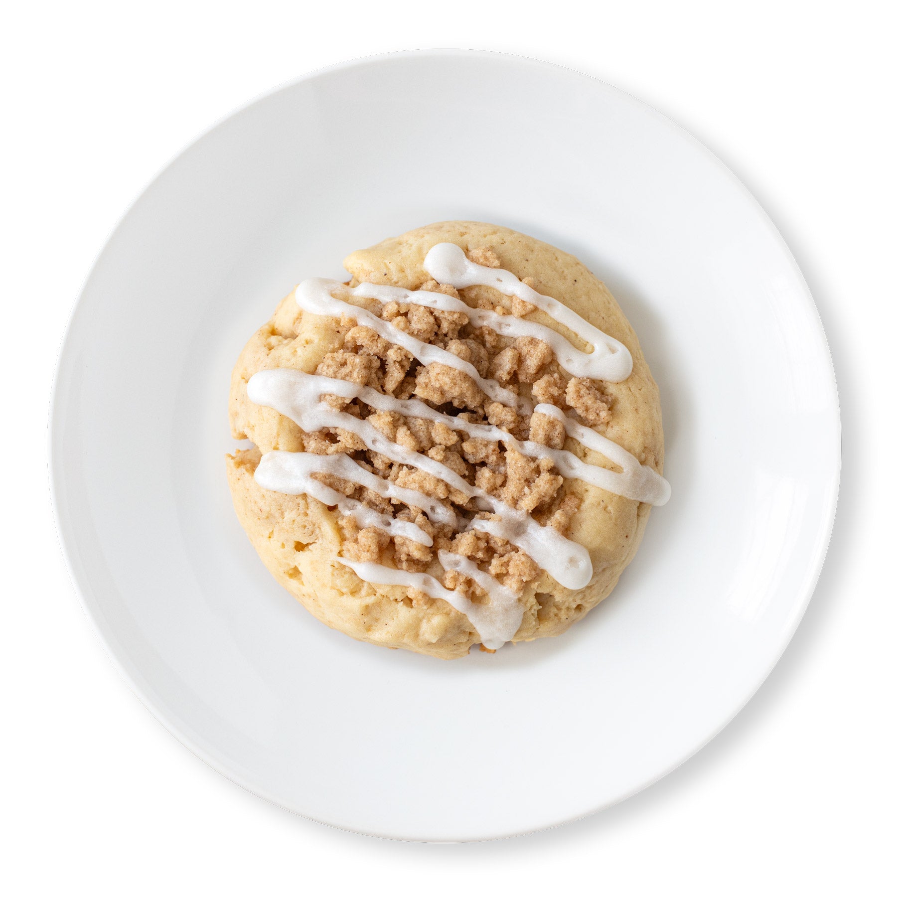 Overhead view of a Crumb Cake Cookie with a crumbly streusel topping and a vanilla glaze drizzle on a white plate.