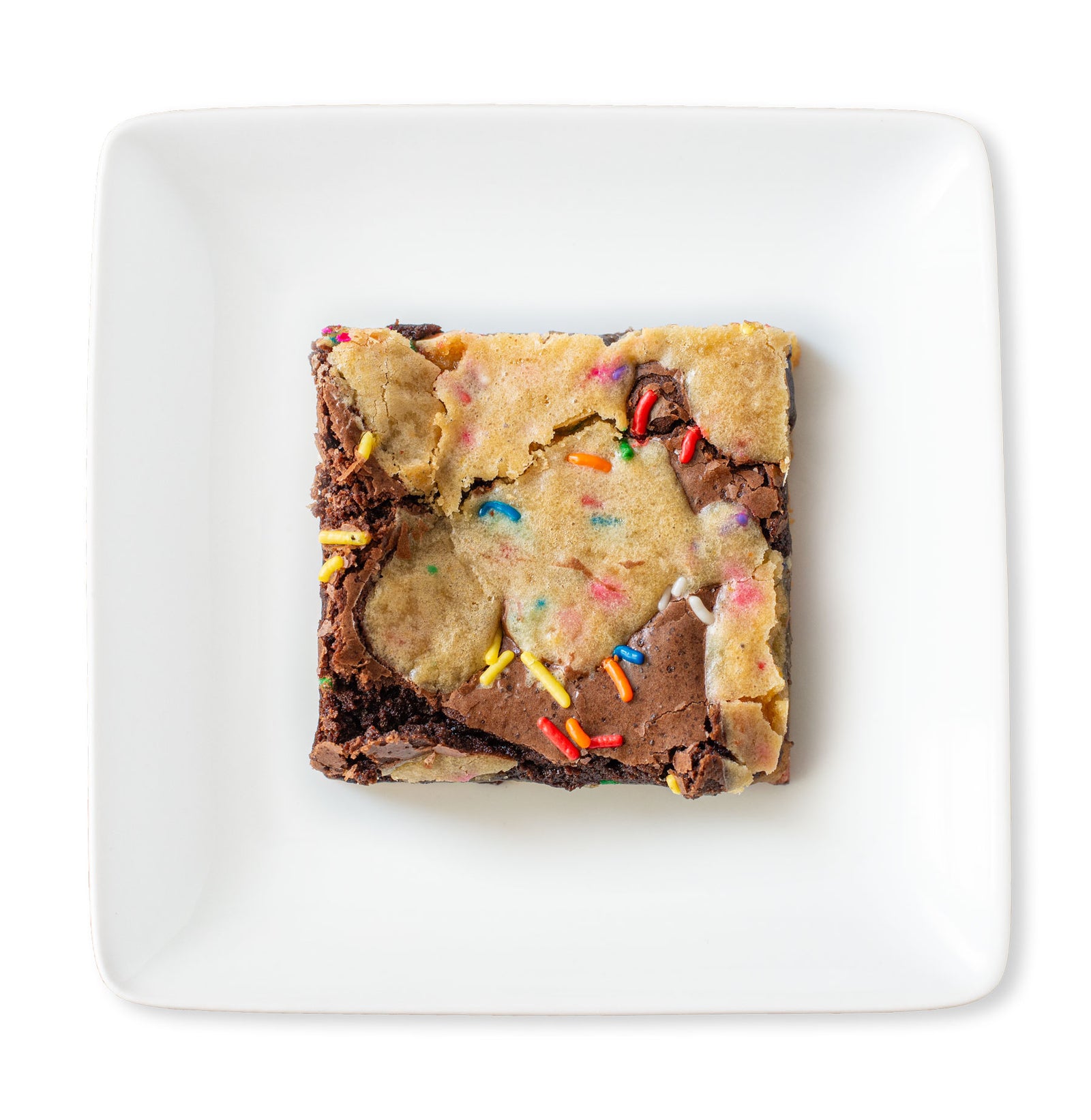 A mouthwatering image of a Birthday Cake Brownie, featuring layers of fudgy chocolate brownie and cake-flavored cookie dough, topped with dollops of cookie dough.