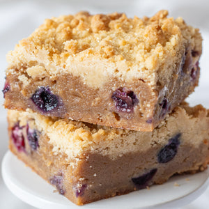 Two Blueberry Crumb Blondie bars stacked on top of each other, highlighting their soft and chewy texture and buttery crumble topping.