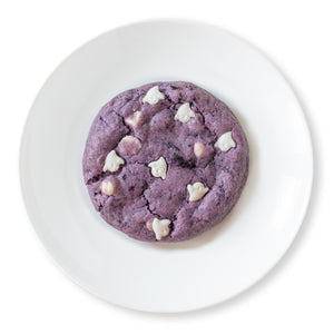 Boo-Berry cookie with white ghost-shaped sprinkles on a white plate