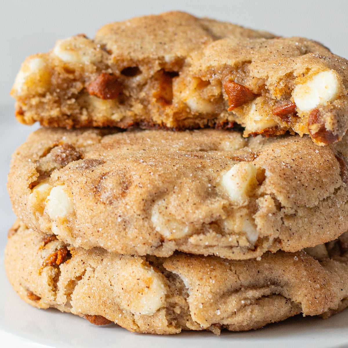 A tantalizing image of Cinnamon Lovers Cookies with visible cinnamon chips and white chocolate chips, coated in a delightful cinnamon sugar crust.