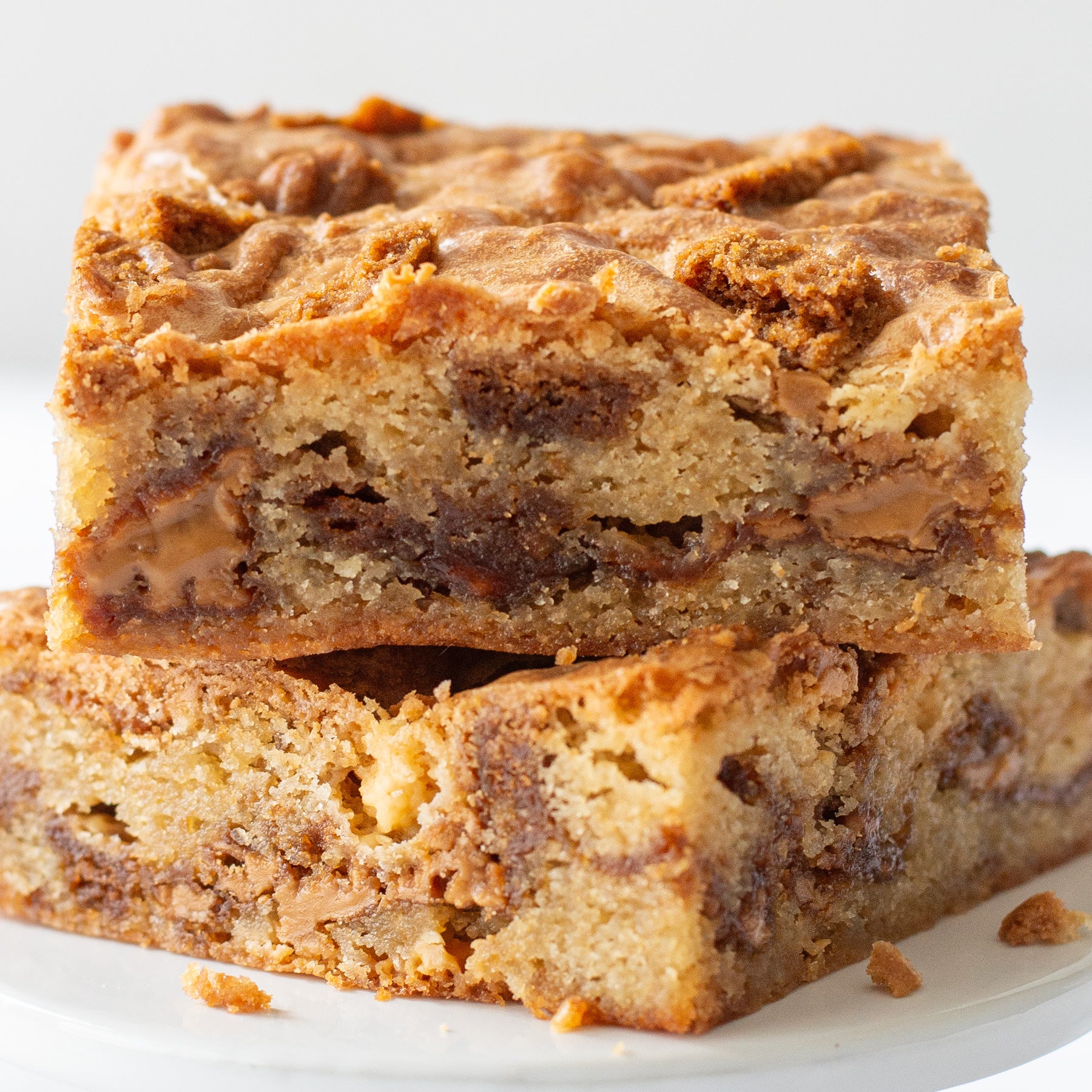 Two Cookie Butter Blondies stacked on a white plate