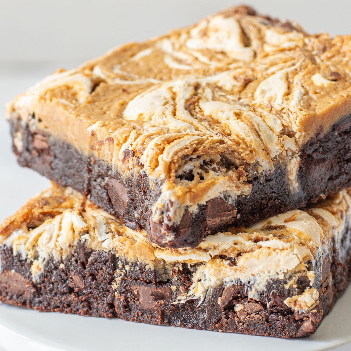 A close-up image of a Fluffernutter Brownie with visible layers of rich chocolate brownie, peanut butter filling, and marshmallow creme.