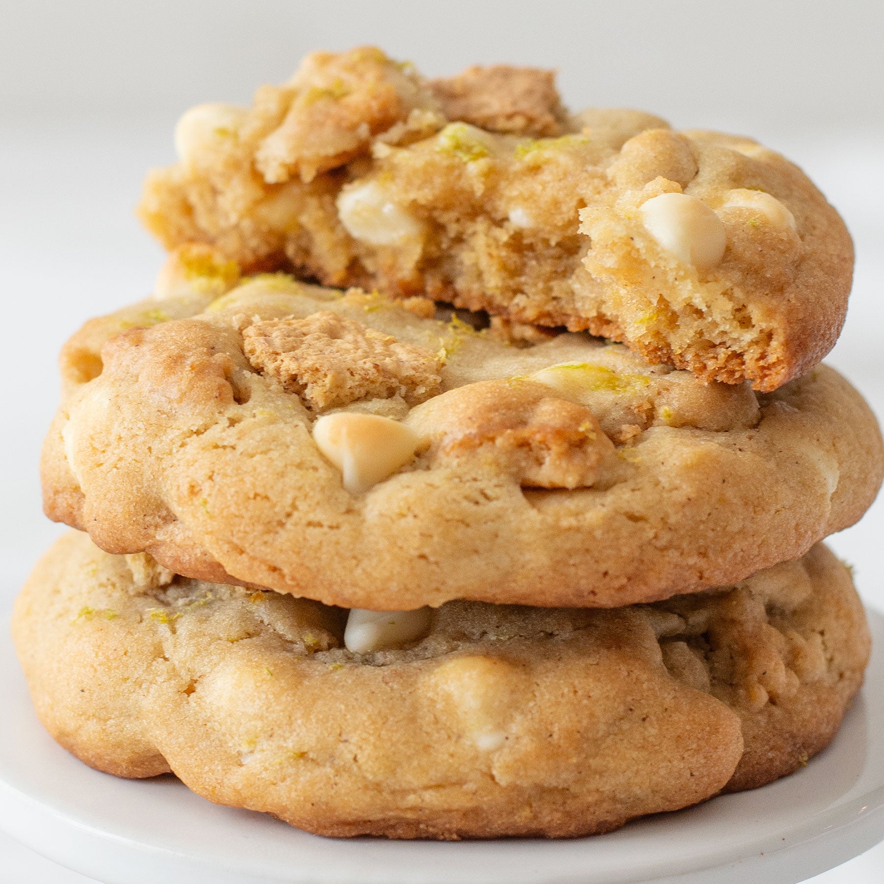 Overhead shot of a Key Lime Cookie on a plate, showing a soft, crinkled top with visible white chocolate chips and graham cracker bits.