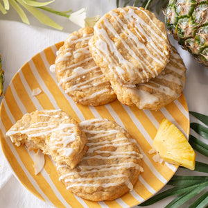 Freshly baked pineapple coconut cookies arranged on a plate, garnished with crunchy coconut chips and a vibrant slice of pineapple, inviting a tropical feast for the eyes.