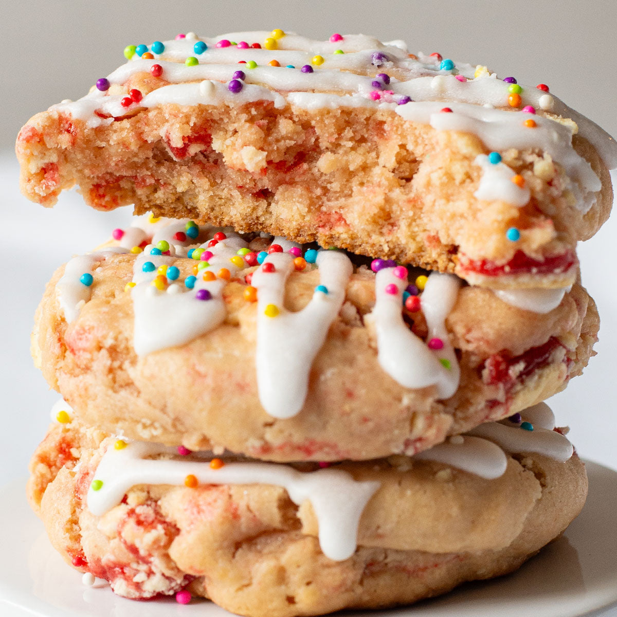 Close-up of a Strawberry Pop Tart Cookie topped with vanilla glaze and colorful nonpareils.