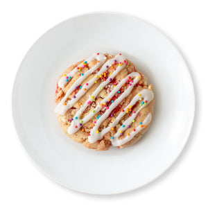 Close-up of a Strawberry Pop Tart Cookie topped with vanilla glaze and colorful nonpareils.